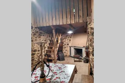 a room with a table and a stone wall at Casa da Penisquela in O Barco de Valdeorras