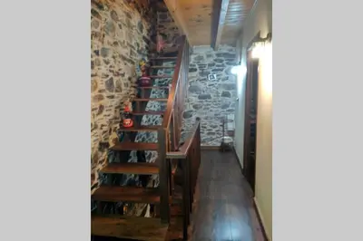 a staircase in a room with a wall of wine bottles at Casa da Penisquela in O Barco de Valdeorras