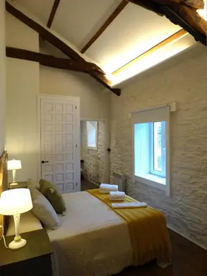 a bedroom with a large bed and a window at Apartamentos Minas de Silvarosa in Viveiro