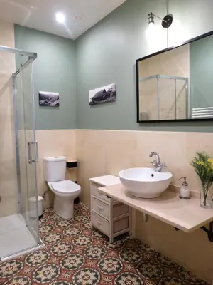 a bathroom with a sink and a toilet and a mirror at Apartamentos Minas de Silvarosa in Viveiro