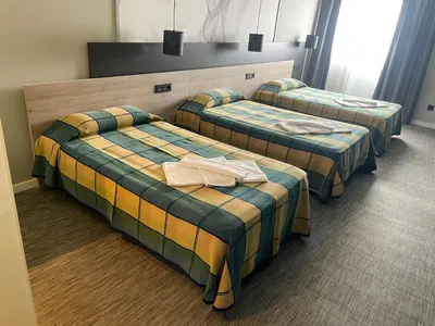 a hotel room with three beds with towels on them at Area 507 in Outeiro de Rei