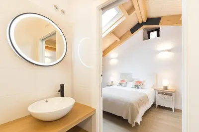 a bathroom with a sink and a bed with a mirror at Landras de Compostela in Santiago de Compostela