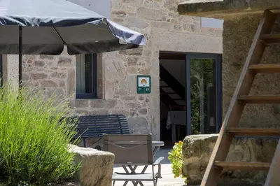 a patio with an umbrella and a table and a chair at Landras de Compostela in Santiago de Compostela