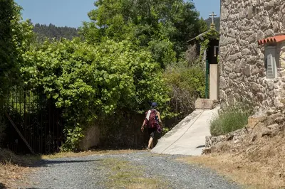 a person walking down a road next to a stone building at Landras de Compostela in Santiago de Compostela