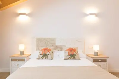 a bedroom with a white bed with flowers on it at Landras de Compostela in Santiago de Compostela