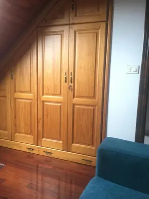 a room with wooden cabinets and a blue couch at A boa vista in Melide