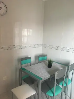 a dining room table and chairs with a clock on the wall at A boa vista in Melide