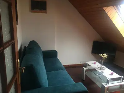 a living room with a blue couch and a table at A boa vista in Melide
