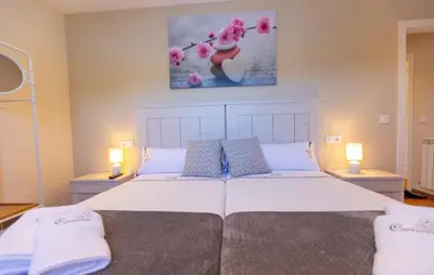 a bedroom with a large white bed with two lamps at 