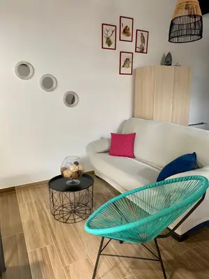 a living room with a white couch and a table at Estudio Pajar rural con bonito jardín - Los Gayoles Rural in Castropol