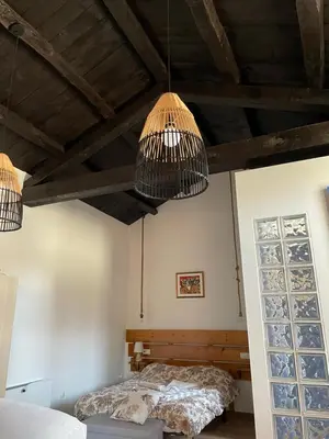 a bedroom with two beds and two chandeliers at Estudio Pajar rural con bonito jardín - Los Gayoles Rural in Castropol