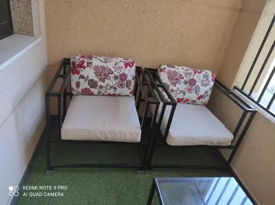 two chairs with floral cushions sitting on a balcony at El Mirador de la Villa in Puebla de Sanabria