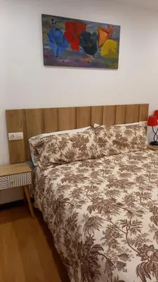 a bedroom with a bed and a painting on the wall at AT El Manzano - Jardín & BBQ - Los Gayoles Rural in Castropol