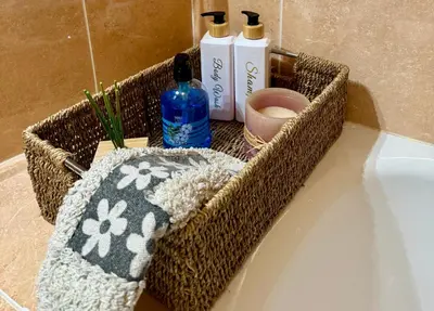 a basket on a bathroom counter with shampoo and a towel at FANTASTICO APARTAMENTO EN RIBADEO in Ribadeo