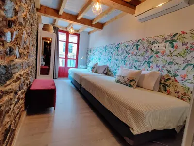 a room with two beds and a stone wall at La Casita de la Ribeira Sacra in Monforte de Lemos