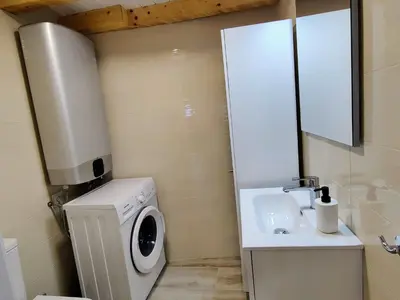 a small bathroom with a washing machine and a sink at La Casita de la Ribeira Sacra in Monforte de Lemos