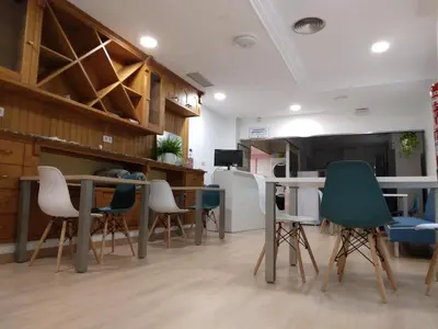 a room with chairs and tables and a tv at A Fonte De Compostela in Santiago de Compostela