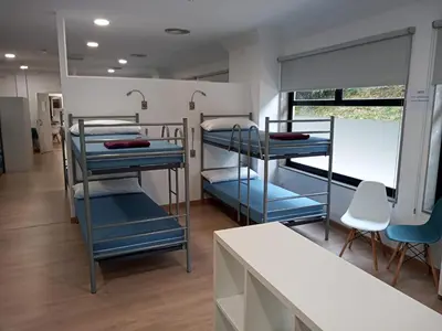 a room with three bunk beds and a table at A Fonte De Compostela in Santiago de Compostela