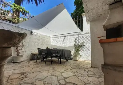 a patio with a table and a white umbrella at Cabanela Maitia Apto Matteo Barbacoa in Ribadeo