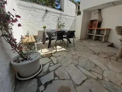 a patio with a table and chairs and a potted plant at Cabanela Maitia Apto Matteo Barbacoa in Ribadeo