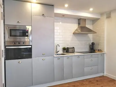 a kitchen with white cabinets and a microwave at Cabanela Maitia Apto Matteo Barbacoa in Ribadeo