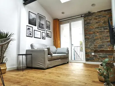 a living room with a couch and a brick wall at Cabanela Maitia Apto Matteo Barbacoa in Ribadeo