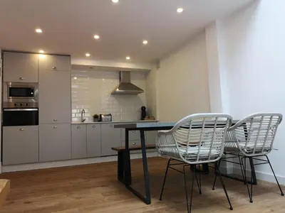 a kitchen with a table and two chairs at Cabanela Maitia Apto Matteo Barbacoa in Ribadeo
