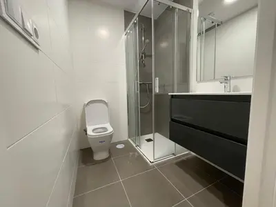 a bathroom with a toilet and a glass shower at Oktheway Areal in Oleiros