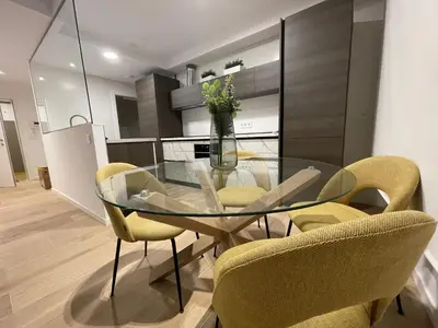 a glass dining room table with yellow chairs in a kitchen at Oktheway Areal in Oleiros