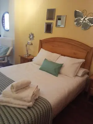 a bedroom with a bed with towels on it at Apartamento en Viveiro (Casco histórico) in Viveiro