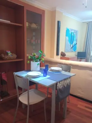 a dining room table with two chairs and a blue table at Apartamento en Viveiro (Casco histórico) in Viveiro