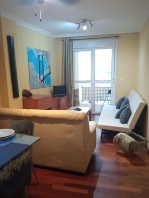 a living room with a couch and a balcony at Apartamento en Viveiro (Casco histórico) in Viveiro