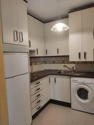 a kitchen with white cabinets and a washing machine at Apartamento en Viveiro (Casco histórico) in Viveiro