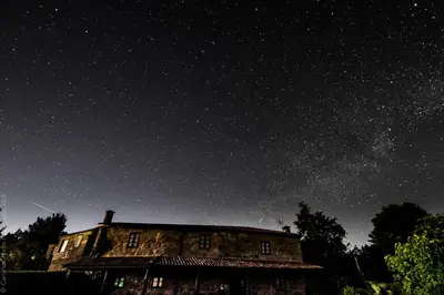 an old house under a starry sky at night at Casa Baralló in Lobios