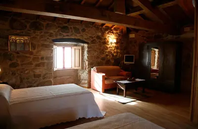 a bedroom with a bed and a couch and a window at Casa Baralló in Lobios