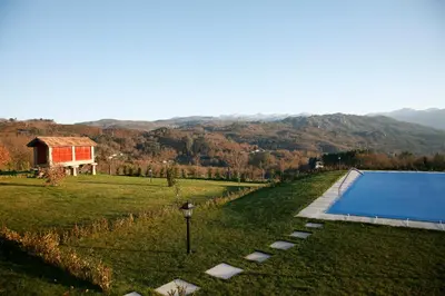 a swimming pool in a field next to a house at Casa Baralló in Lobios
