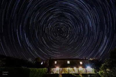 a star trails over a house at night at Casa Baralló in Lobios