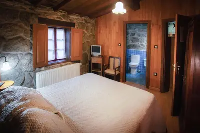 a bedroom with a bed and a bathroom with a toilet at Casa Baralló in Lobios