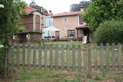 a wooden fence in front of a house at Casa Pousadoira in Miño