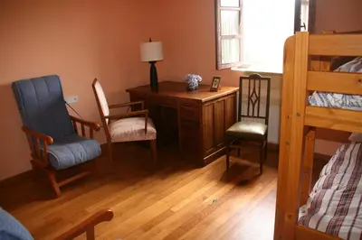 a bedroom with a desk and two chairs and a bed at Casa Pousadoira in Miño