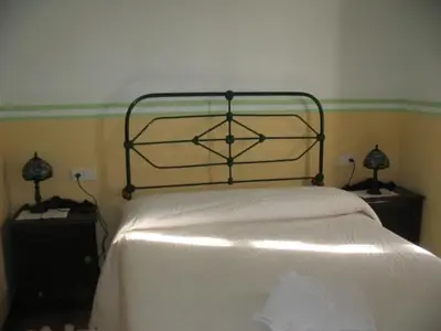 a bedroom with a white bed with two night stands at Casa Pousadoira in Miño