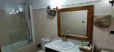 a bathroom with a sink and a mirror and a toilet at Casa Rousia in Baltar