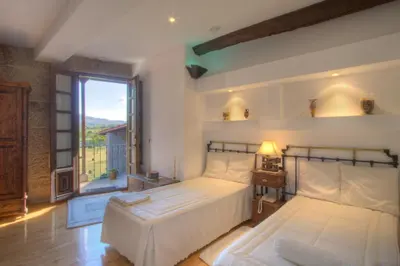 a bedroom with two beds and a large window at Casa Rousia in Baltar
