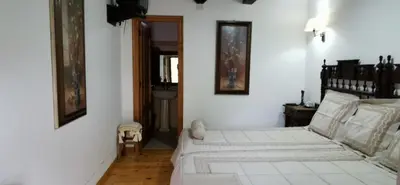 a white bedroom with a bed and a sink at Casa Rousia in Baltar