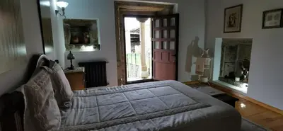 a bedroom with a bed and a window and a door at Casa Rousia in Baltar