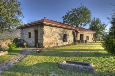a stone house with a yard in front of it at Casa Rousia in Baltar