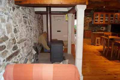 a stove in a room with a stone wall at Casa Brues in Boborás