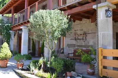 a porch of a building with a tree and a bench at Casa Brues in Boborás