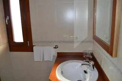 a bathroom with a sink and a mirror and towels at Casa Brues in Boborás
