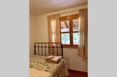 a small bedroom with a bed with pink pillows at Casa rural: Villa Marías in Sampil